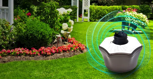 Mosquito trap on a lawn beside a flower garden, with a protective glow around it. Mosquito Free World Google Ads creative by Sigil Advertising.