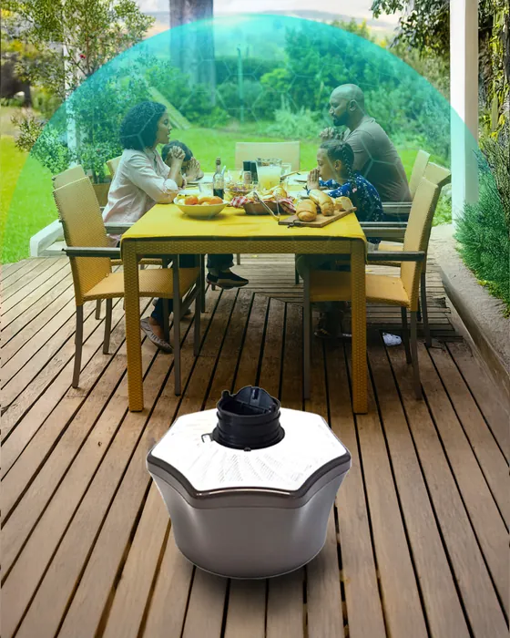 Mosquito trap on a deck beside a family dining outdoors. Mosquito Free World Google Ads creative by Sigil Advertising.